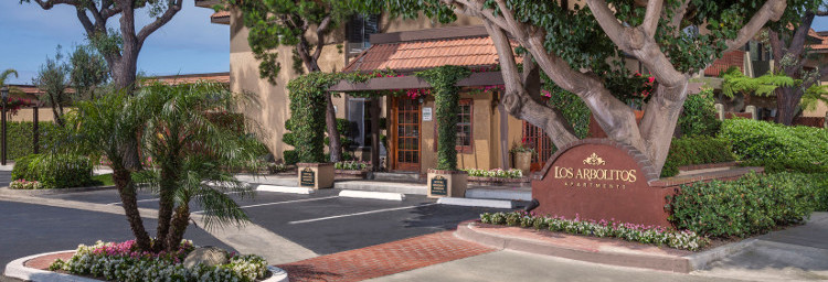 Rental office surrounded by lovely trees and flowers.